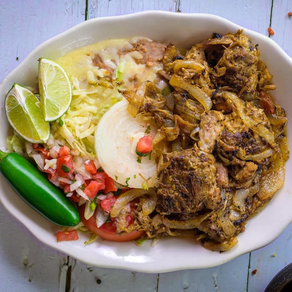 Cantina Caramba!'s carne asada with grilled onions, refried beans, pico de gallo, lime, and jalapeño.